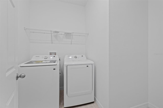 laundry room with laundry area, independent washer and dryer, and baseboards