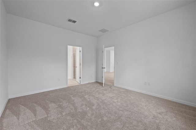 unfurnished bedroom with visible vents, baseboards, and light colored carpet