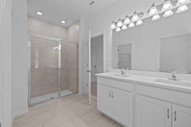 full bathroom featuring double vanity, a shower stall, visible vents, and a sink