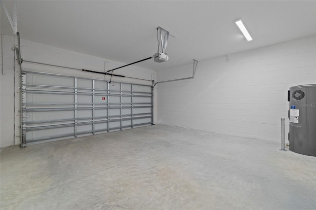 garage featuring concrete block wall, water heater, and a garage door opener