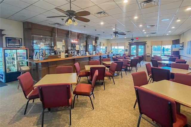 bar featuring ceiling fan, light colored carpet, and a paneled ceiling