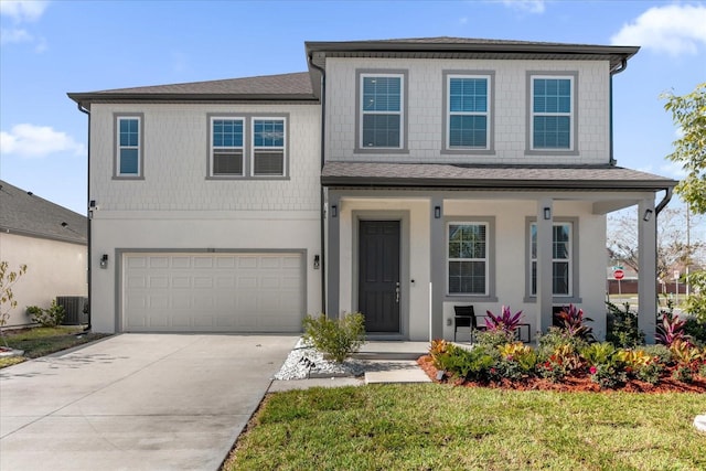 view of front of home featuring a front yard, a garage, and central AC unit