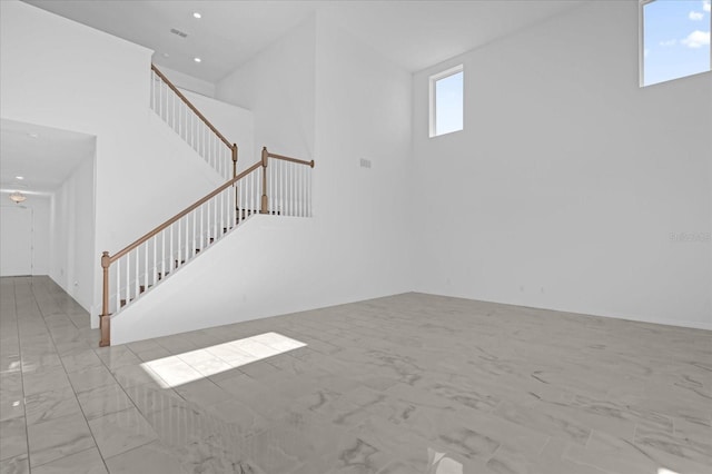 unfurnished living room with a towering ceiling