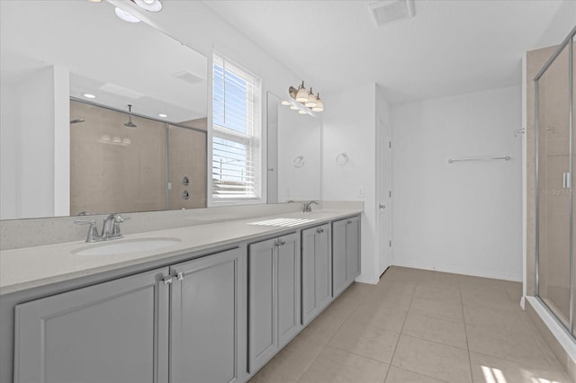 bathroom featuring tile patterned flooring, vanity, and a shower with door