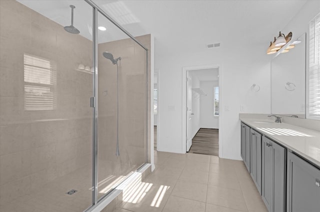 bathroom with tile patterned floors, vanity, and a shower with shower door