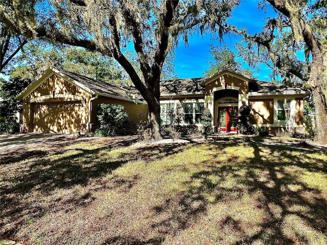 ranch-style home featuring a garage and a front lawn