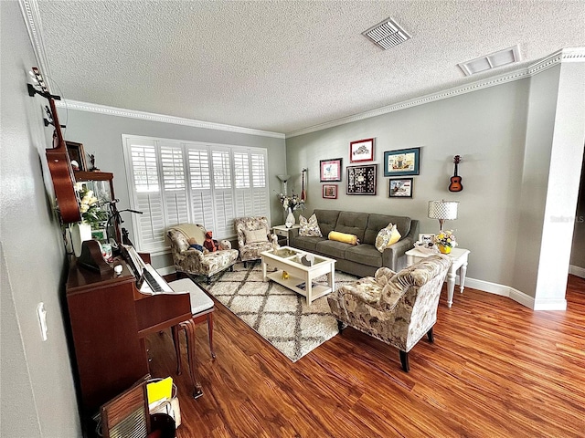 living room featuring hardwood / wood-style floors, a textured ceiling, and crown molding