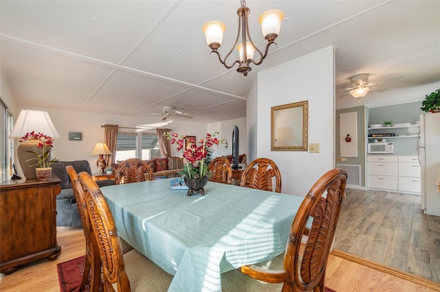 dining room featuring ceiling fan with notable chandelier and light hardwood / wood-style floors