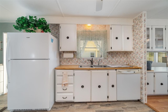 kitchen with sink, white appliances, white cabinets, and light wood-type flooring