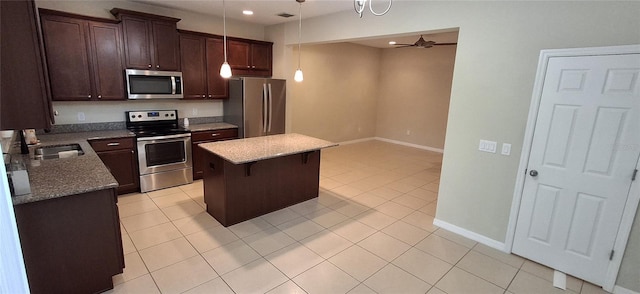 kitchen featuring a center island, sink, ceiling fan, light tile patterned floors, and appliances with stainless steel finishes