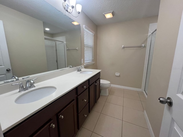 bathroom with a textured ceiling, tile patterned floors, toilet, and walk in shower