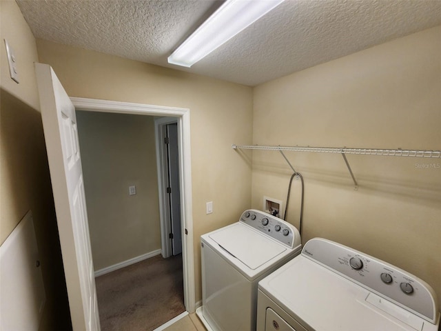 clothes washing area with separate washer and dryer, carpet floors, and a textured ceiling