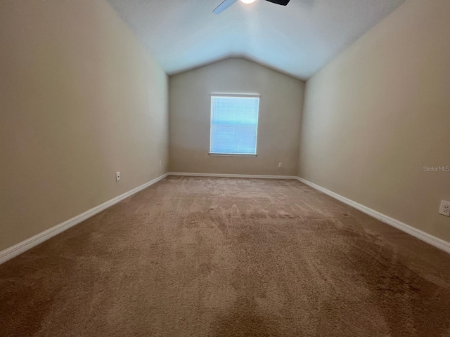 carpeted empty room featuring lofted ceiling and ceiling fan