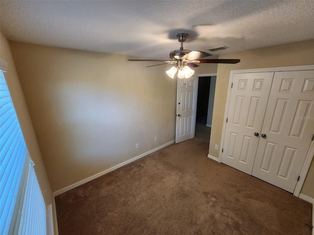 unfurnished bedroom featuring ceiling fan, carpet floors, a closet, and a textured ceiling