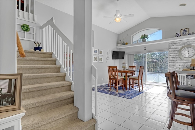 dining room featuring ceiling fan, high vaulted ceiling, and tile patterned floors