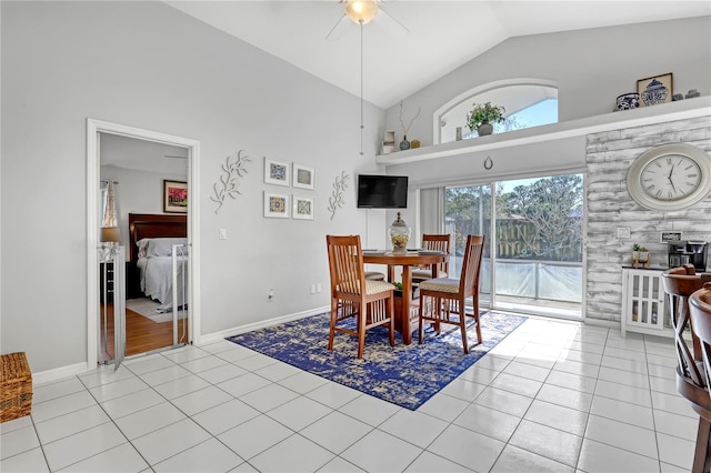 dining space with high vaulted ceiling, light tile patterned flooring, and ceiling fan