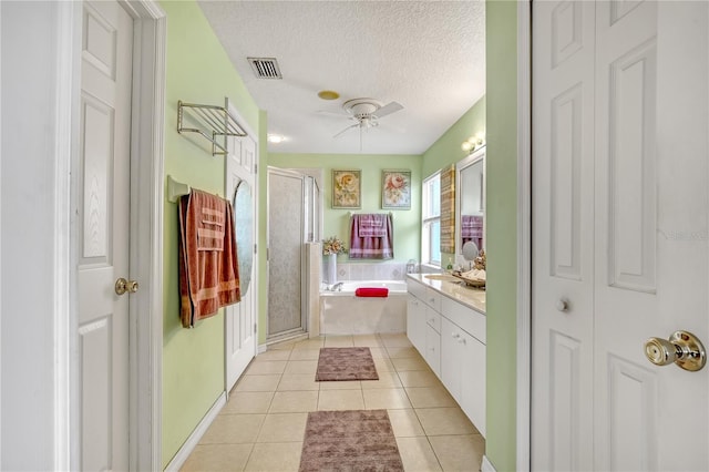 bathroom with a textured ceiling, shower with separate bathtub, tile patterned floors, ceiling fan, and vanity