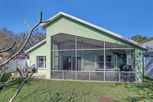 back of property featuring a yard and a sunroom