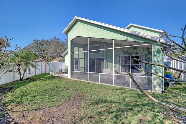 rear view of property with a lawn and a sunroom