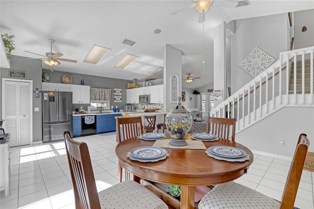 tiled dining space featuring sink, ceiling fan, and lofted ceiling