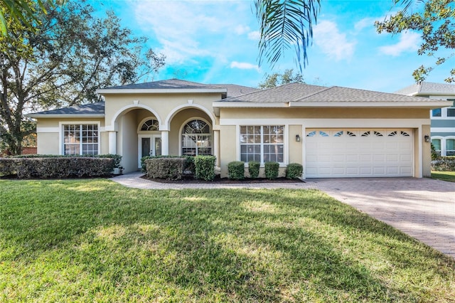 view of front of house featuring a garage and a front lawn