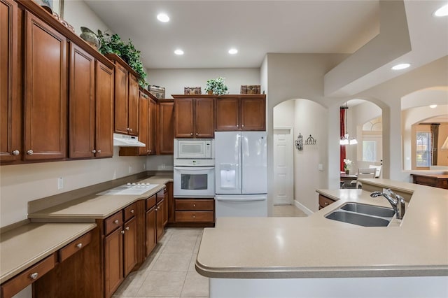 kitchen featuring white appliances, a kitchen island with sink, light tile patterned floors, and sink