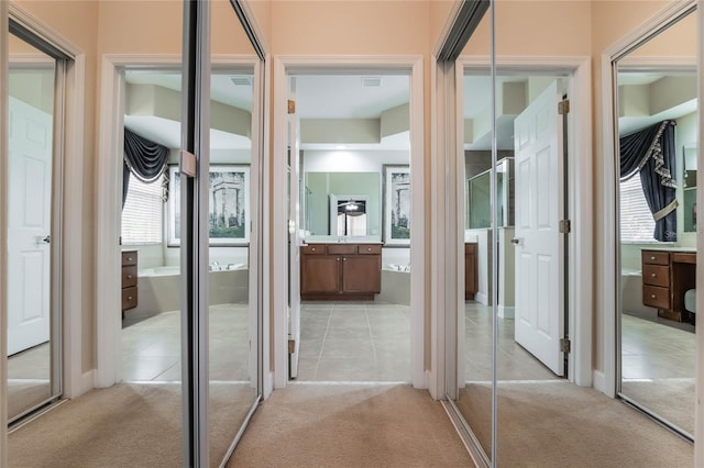 corridor with light colored carpet and a wealth of natural light