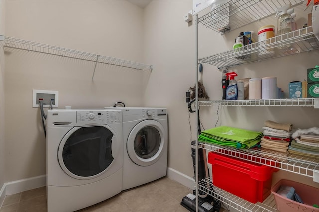 laundry room featuring washing machine and dryer and light tile patterned flooring