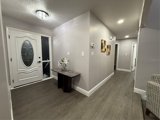 entryway with a textured ceiling and dark hardwood / wood-style flooring