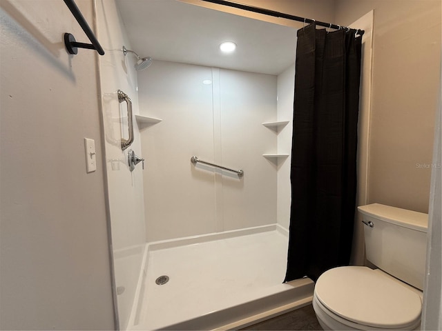 bathroom with toilet and a shower with curtain