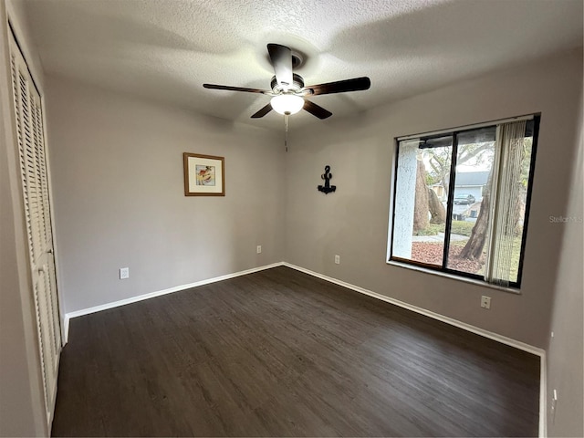 unfurnished bedroom featuring ceiling fan, a closet, dark hardwood / wood-style flooring, and a textured ceiling