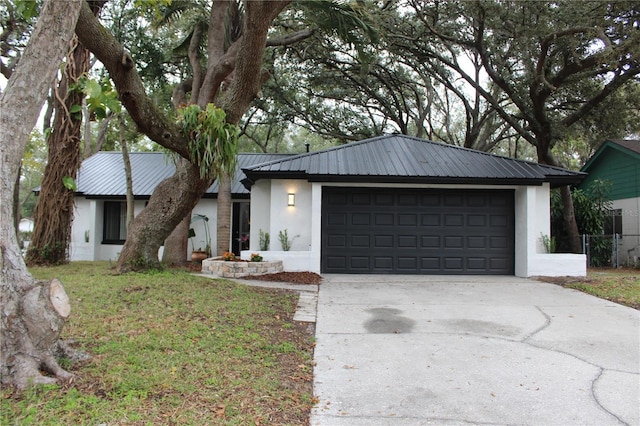 single story home with a garage and a front lawn