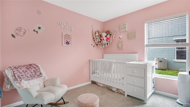 carpeted bedroom featuring a nursery area