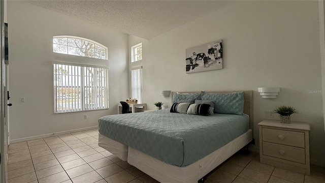 bedroom featuring light tile patterned floors and a textured ceiling