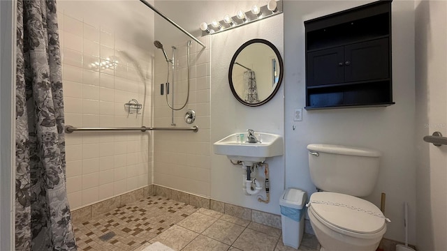 bathroom featuring tile patterned flooring, toilet, and curtained shower