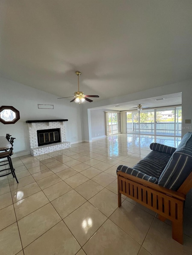 unfurnished living room featuring a fireplace, light tile patterned floors, a wealth of natural light, and ceiling fan