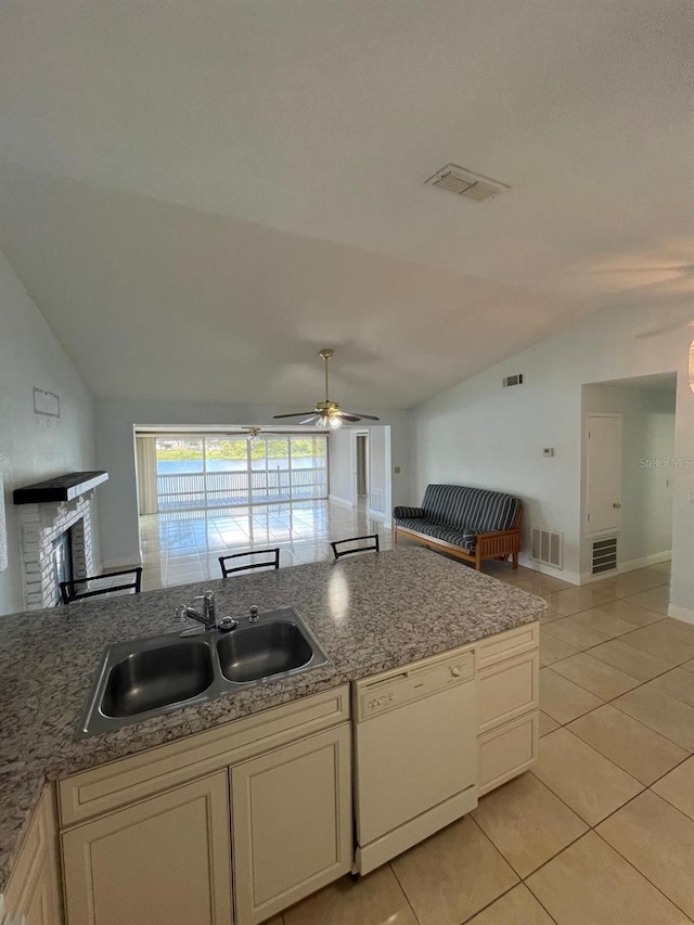 kitchen featuring dishwasher, lofted ceiling, sink, ceiling fan, and light tile patterned floors