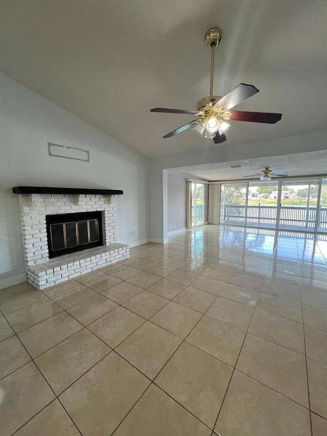 unfurnished living room with light tile patterned floors, vaulted ceiling, a brick fireplace, and ceiling fan