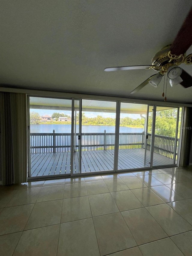 unfurnished sunroom with a water view and ceiling fan