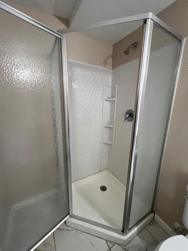 bathroom with an enclosed shower and toilet