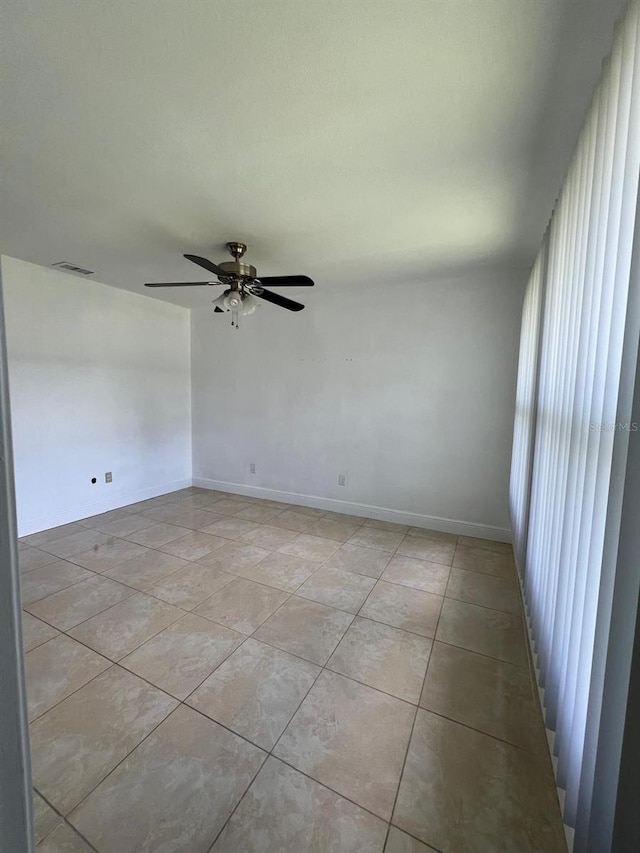 tiled empty room with ceiling fan