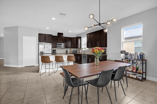 dining area with light tile patterned floors and a chandelier