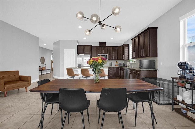 tiled dining room with a chandelier