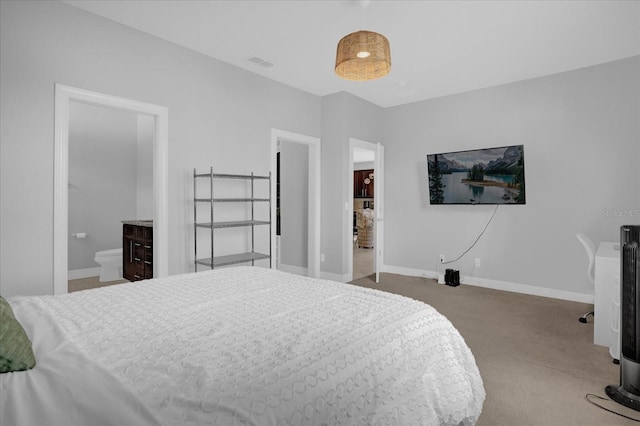 bedroom featuring light colored carpet and ensuite bath