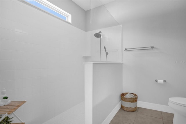 bathroom featuring tile patterned floors, toilet, and tiled shower