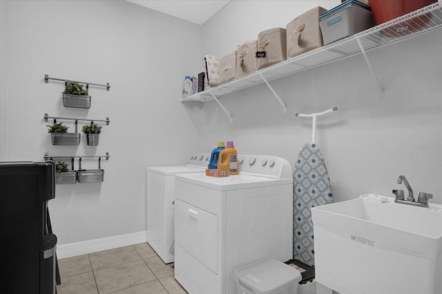 laundry room featuring light tile patterned floors, sink, and washing machine and clothes dryer