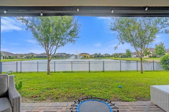 view of yard featuring a water view and a trampoline