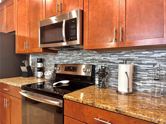 kitchen featuring backsplash, light stone counters, and stainless steel appliances