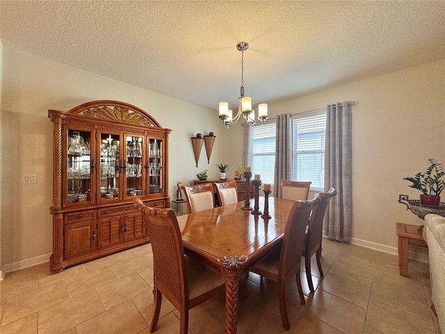 tiled dining space with a textured ceiling and a chandelier