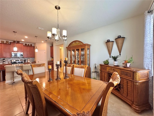 tiled dining area with a chandelier